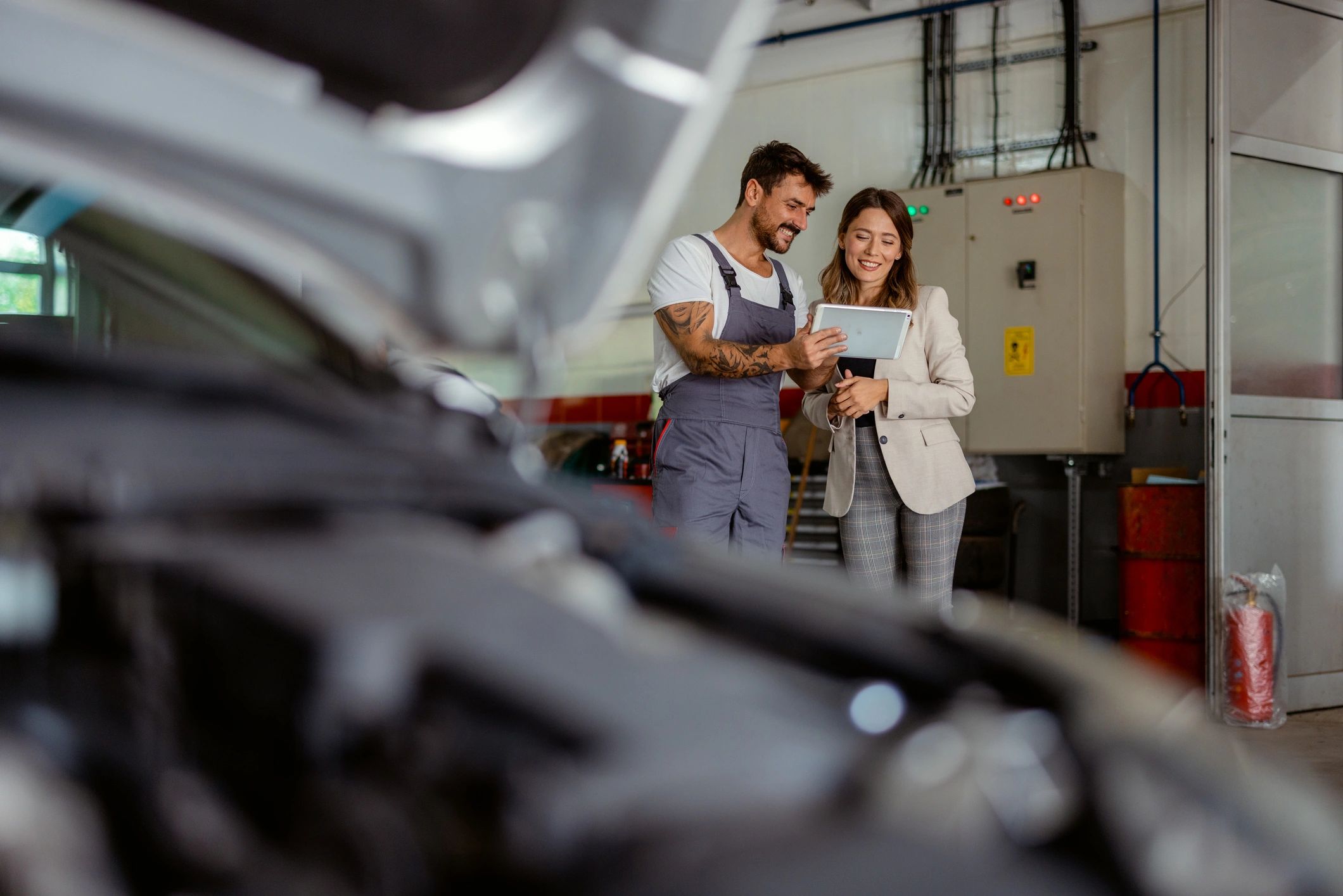 Mechanic explaining service details with a tablet representing exclusionary coverage