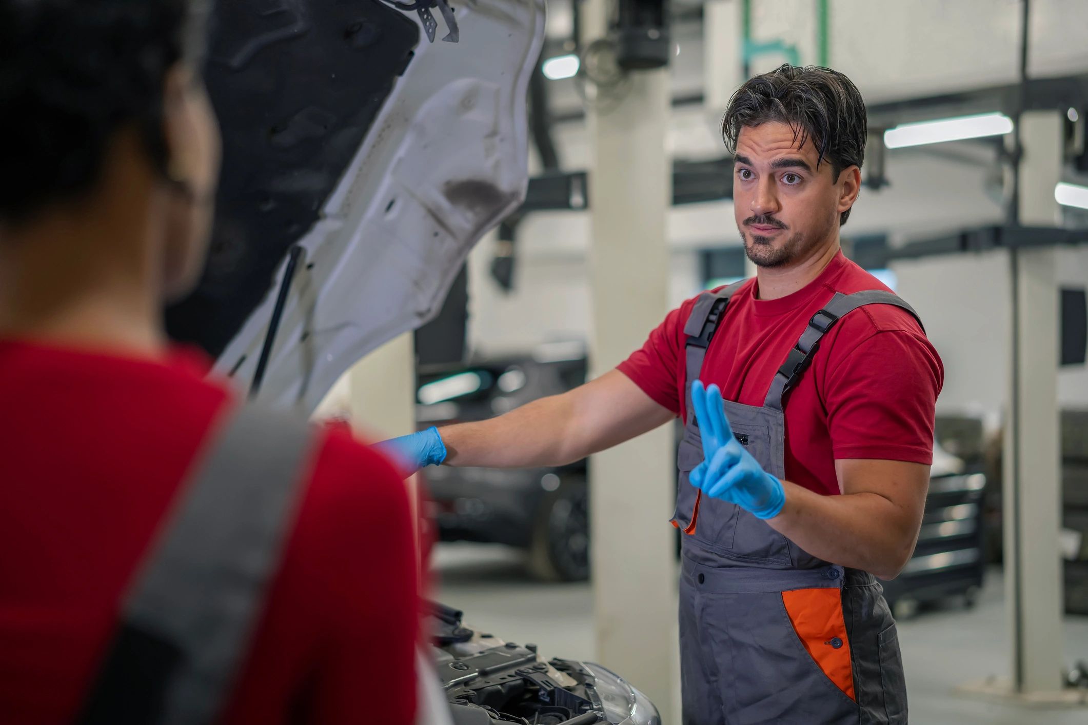 Auto mechanics discussing vehicle service details in a garage